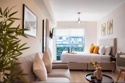 a bedroom with a bed and a living room with a couch at G15 Apartments by Vibrant in Lima
