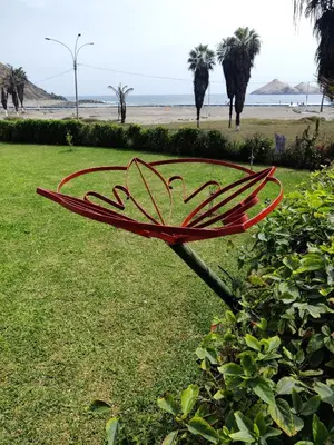 a red bench sitting in the grass near the beach at bungalows in Santa Rosa