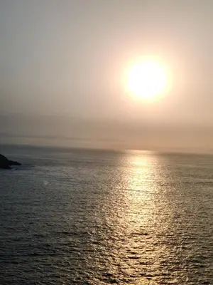 a sunset over the ocean with the sun in the sky at bungalows in Santa Rosa