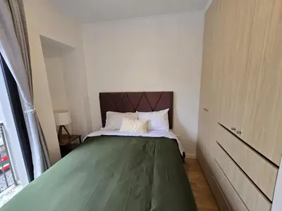 a small bedroom with a bed with a green blanket at Apartamento full equipado en barranco in Lima