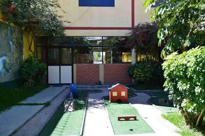 a yard with a toy house in the grass at Kibo Hotel in Ayacucho
