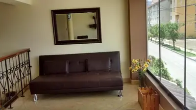 a brown couch in a room with a mirror at Kibo Hotel in Ayacucho