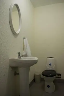 a bathroom with a sink and a toilet and a mirror at Hospedaje Milan in Lima