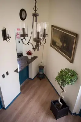 a hallway with a plant and a clock on the wall at Hospedaje Milan in Lima