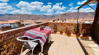 a table and chairs on a balcony with a view at Amira's House Cusco in Cusco