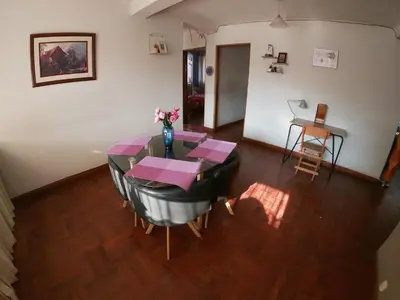 a dining room with a table with a vase of flowers at Departamento céntrico en Cusco in Cusco