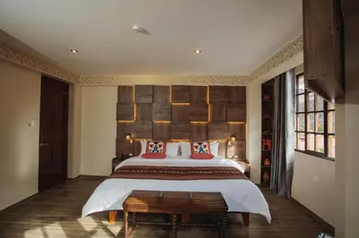 a bedroom with a large bed and a wooden headboard at Valle Del Sol in Urubamba