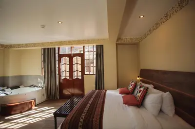 a bedroom with a bed and a tub in a room at Valle Del Sol in Urubamba
