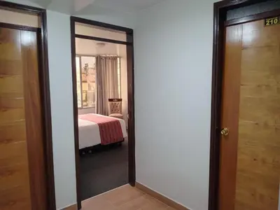 a door leading to a bedroom with a bed at Hotel Santa Felicita - Centro Histórico in Huancayo