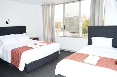 a hotel room with two beds and a window at Hotel Santa Felicita - Centro Histórico in Huancayo