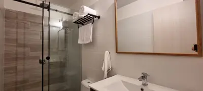 a bathroom with a shower and a sink and a mirror at Apartamento en Miraflores in Lima