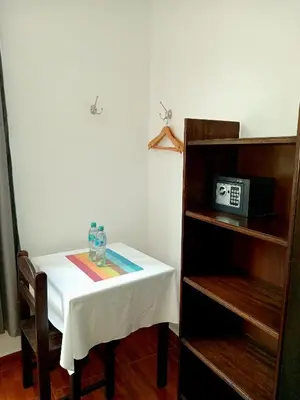 a table with a white table cloth and a clock on it at Susanna Inn MachuPicchu Hotel in Machu Picchu