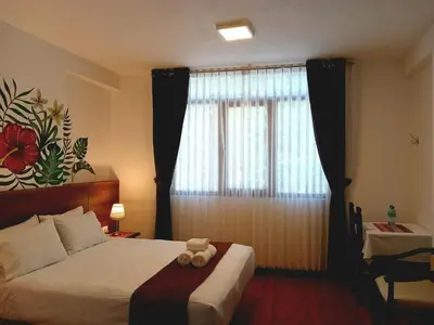 a bedroom with a bed with a teddy bear on it at Susanna Inn MachuPicchu Hotel in Machu Picchu