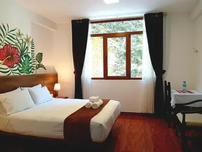 a bedroom with a large bed and a window at Susanna Inn MachuPicchu Hotel in Machu Picchu