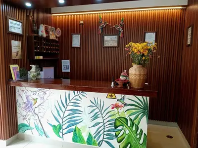 a lobby with a counter with a vase of flowers at Susanna Inn MachuPicchu Hotel in Machu Picchu
