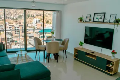 a living room with a television and a table with chairs at Willka Wasi Cusco in Cusco