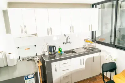 a kitchen with white cabinets and a sink at Willka Wasi Cusco in Cusco