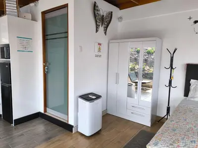 a room with a bed and a door with a table at Lindo chalet en PUCUSANA in Pucusana