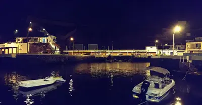 two boats are docked in the water at night at Ninfas 371 in Pucusana