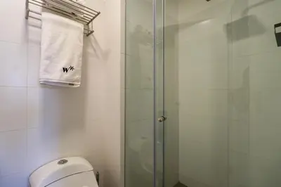 a bathroom with a shower with a toilet and a towel at Stelar by Wynwood House in Lima