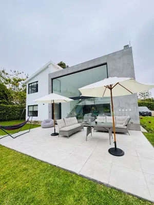 a patio with two white umbrellas in front of a house at Casa Tullpa in Aspitia