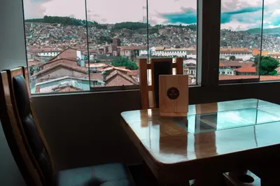 a table in a room with a view of a city at INKALAM cusco in Cusco
