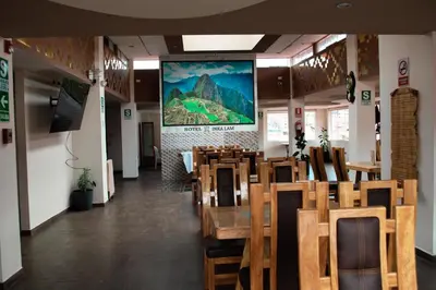 a dining room with tables and chairs and a large screen at INKALAM cusco in Cusco