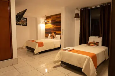 a hotel room with two beds with cats laying on them at Hotel SumacPlaza in Ayacucho
