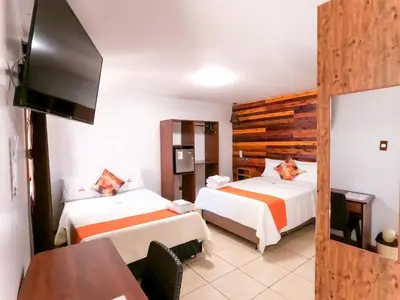 a hotel room with two beds and a flat screen tv at Hotel SumacPlaza in Ayacucho