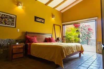 a bedroom with a bed and a large window at Casa Cusco in Cieneguilla