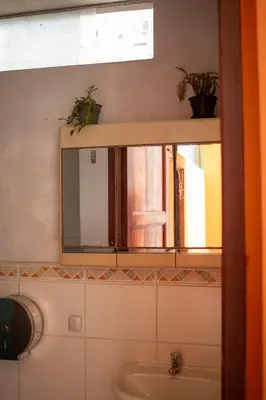 a bathroom with a mirror and a sink at Temazcal Hostel in Lima