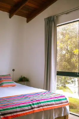 a bedroom with a bed and a large window at Temazcal Hostel in Lima