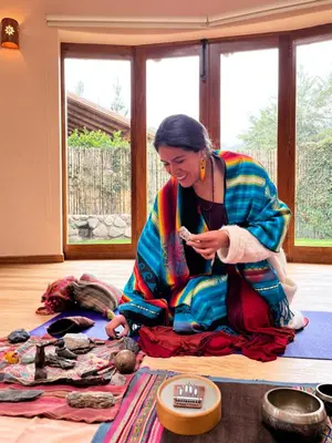 a woman sitting on the floor looking at a piece of art at Casa Tikawarmi in Urubamba