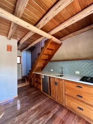 a kitchen with wooden cabinets and a wooden ceiling at Casa Tikawarmi in Urubamba