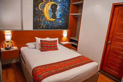 a bedroom with a bed and a painting on the wall at Chakana Hotel Machupicchu in Machu Picchu