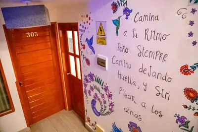 a wall in a room with writing on it at Chakana Hotel Machupicchu in Machu Picchu
