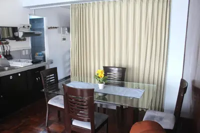 a dining room with a glass table and chairs at Palmeras Apartments San Isidro in Lima
