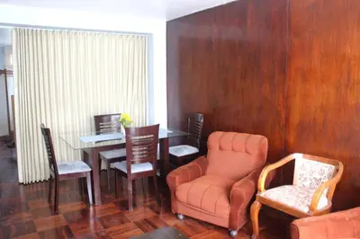 a living room with a chair and a table at Palmeras Apartments San Isidro in Lima