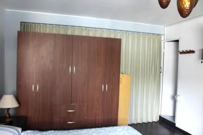 a large wooden cabinet in a bedroom with a bed at Palmeras Apartments San Isidro in Lima