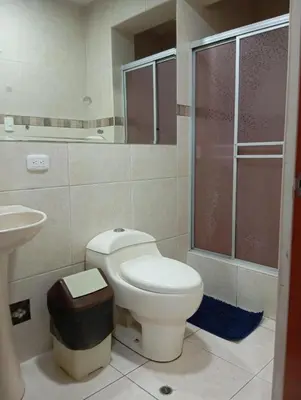 a bathroom with a toilet and a sink at La campiña in Lima