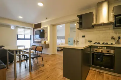 a kitchen and living room with a table and chairs at Moreyra by Wynwood House in Lima