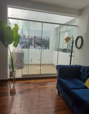 a living room with a blue couch and a large window at Excelente Departamento las viñas in La Molina