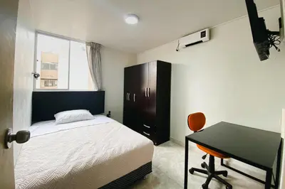 a bedroom with a bed and a desk and a table at Centrico departamento en Lima in Lima
