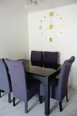 a dining room table with purple chairs and a clock at Centrico departamento en Lima in Lima