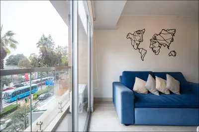 a blue couch in a room with a world map on the wall at Stelar Apartments by Vibrant in Lima