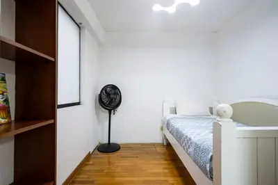 a bedroom with a bed and a floor fan at Nogales Family Apartments by Vibrant in Lima