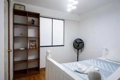 a white bedroom with a bed and a window at Nogales Family Apartments by Vibrant in Lima