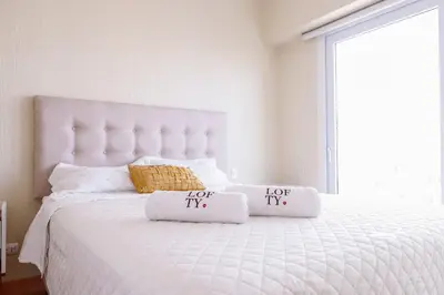 a bedroom with a white bed with two pillows on it at Apartamento Céntrico cerca a San Isidro in Lima