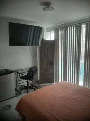 a bedroom with a bed and a desk and a chair at Microdepartamento amoblado in Lima