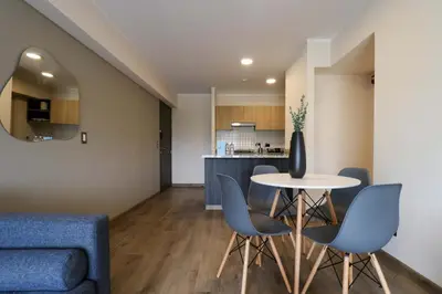 a living room and kitchen with a table and chairs at Benavides by Wynwood House in Lima